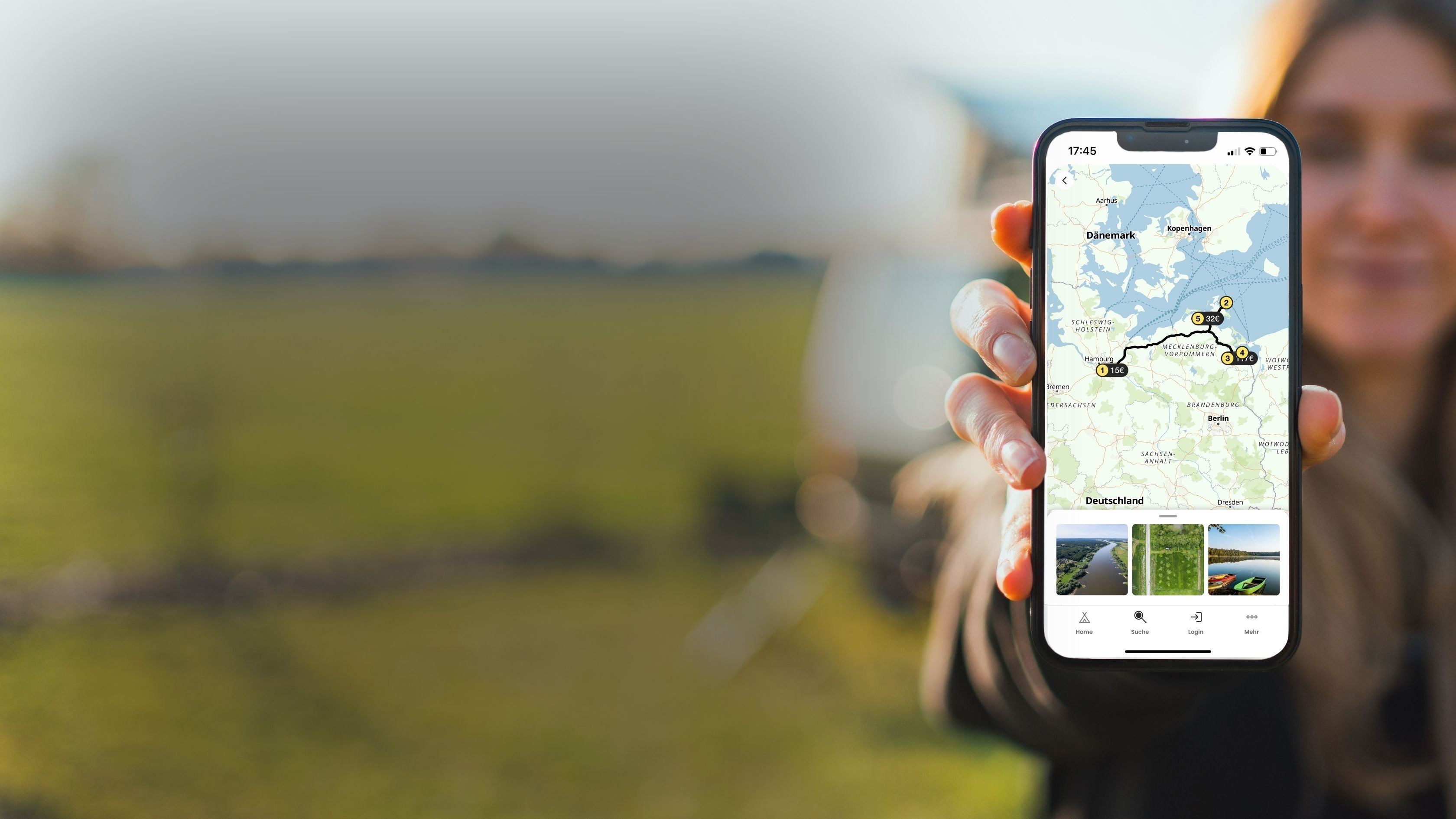 Ein Frau hält ein Handy in der Hand und zeigt es in die Kamera, auf dem man den kostenlosen Routenplaner von hinterland.camp sehen kann. Man erkennt eine Karte, auf der mehrere Stopps zu sehen sind, die mit einander verbunden sind. 