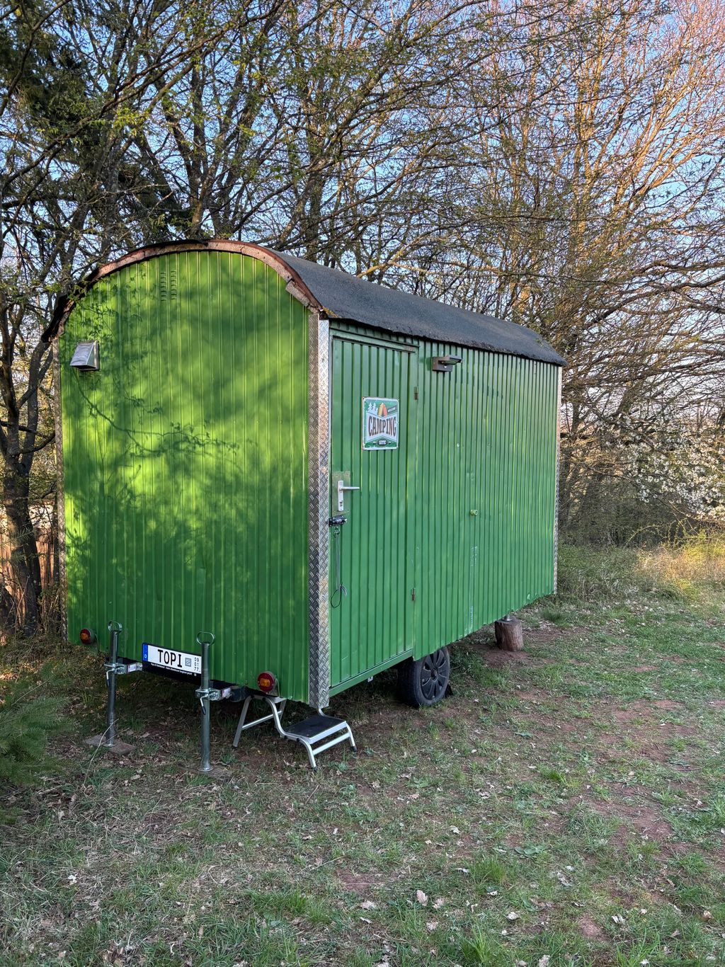 Gemütlicher Forstwagen auf der Wiese am Waldrand