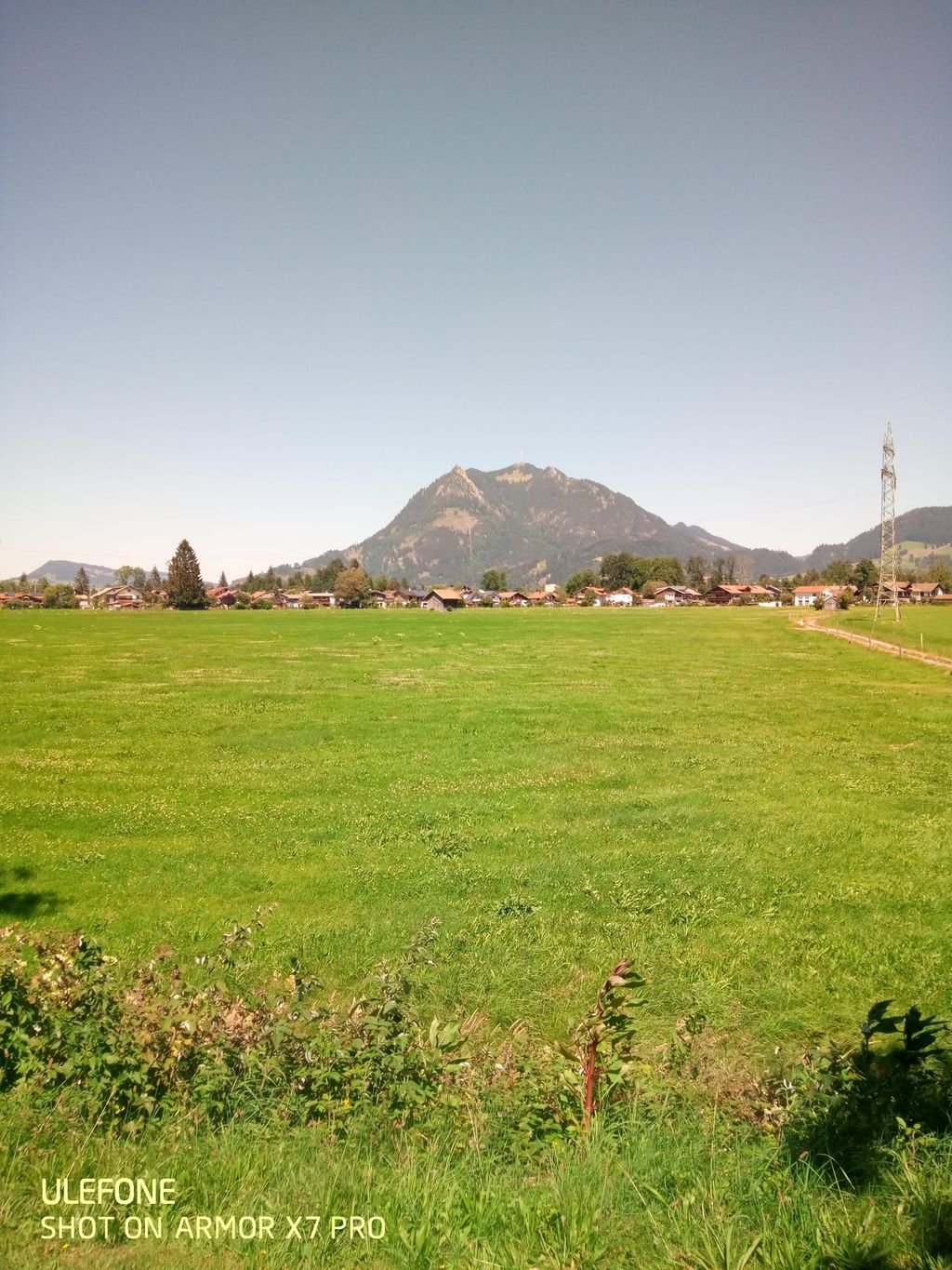 Panorama montano tra campi e sentiero di prati