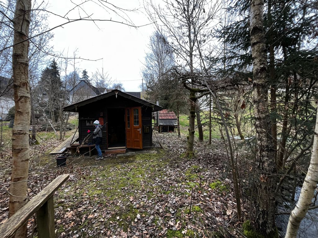 Emplacement au bord du ruisseau avec aire de barbecue et cabane 