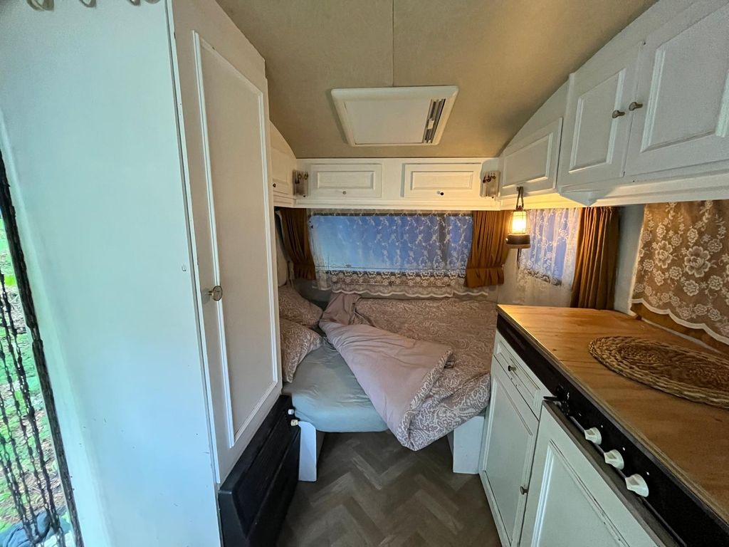 Autarker Retro-Wohnwagen in einem ruhigen Waldgarten