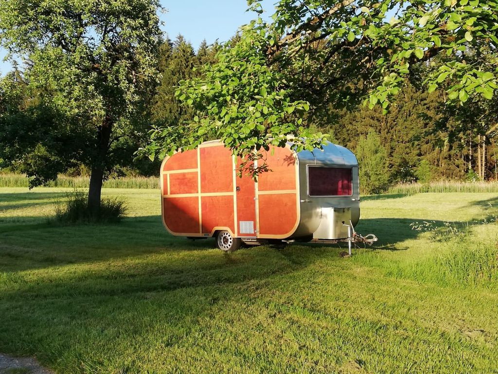 Camper entre des arbres fruitiers avec une vue sur la forêt