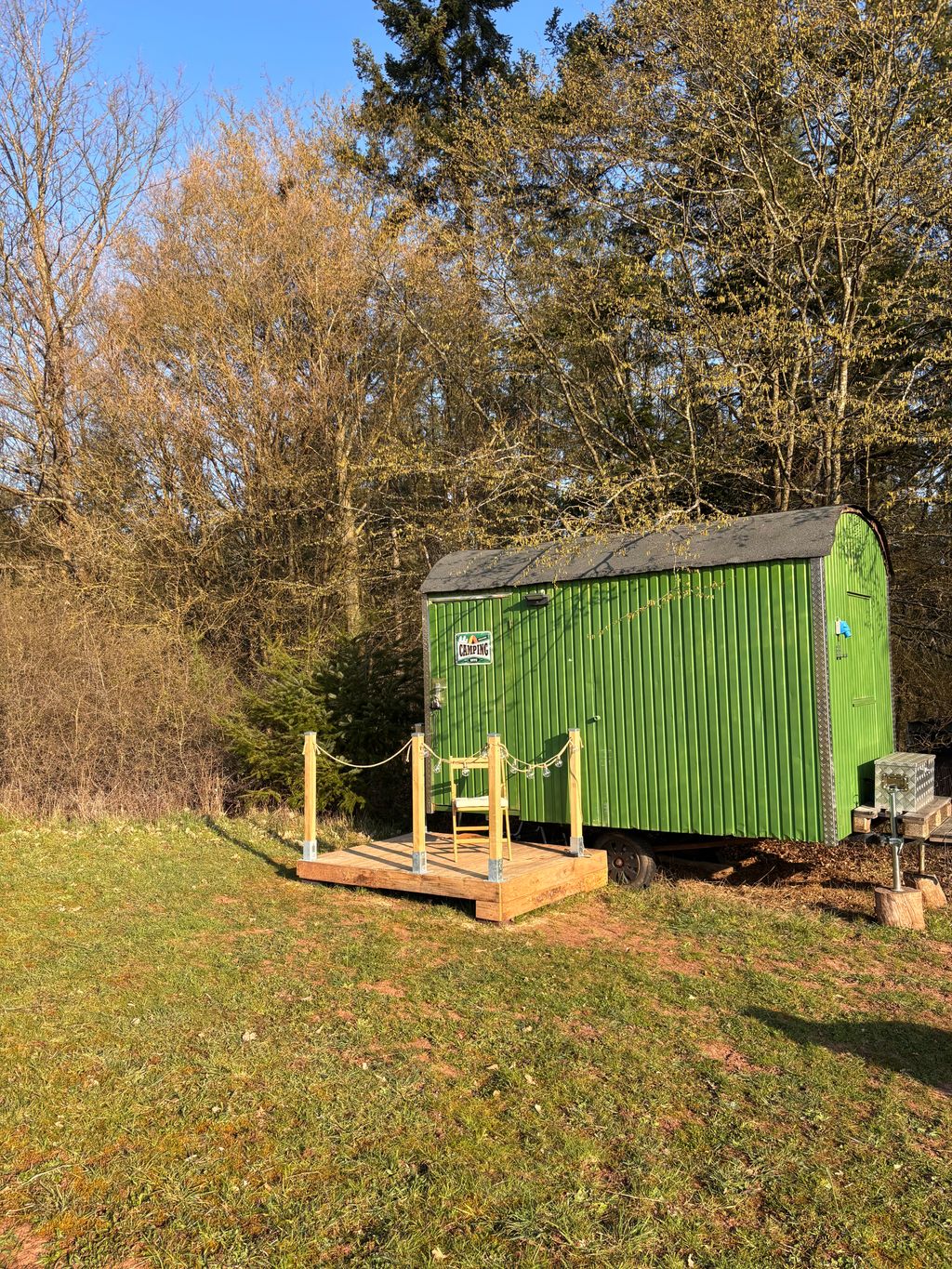 Gemütlicher Forstwagen auf der Wiese am Waldrand
