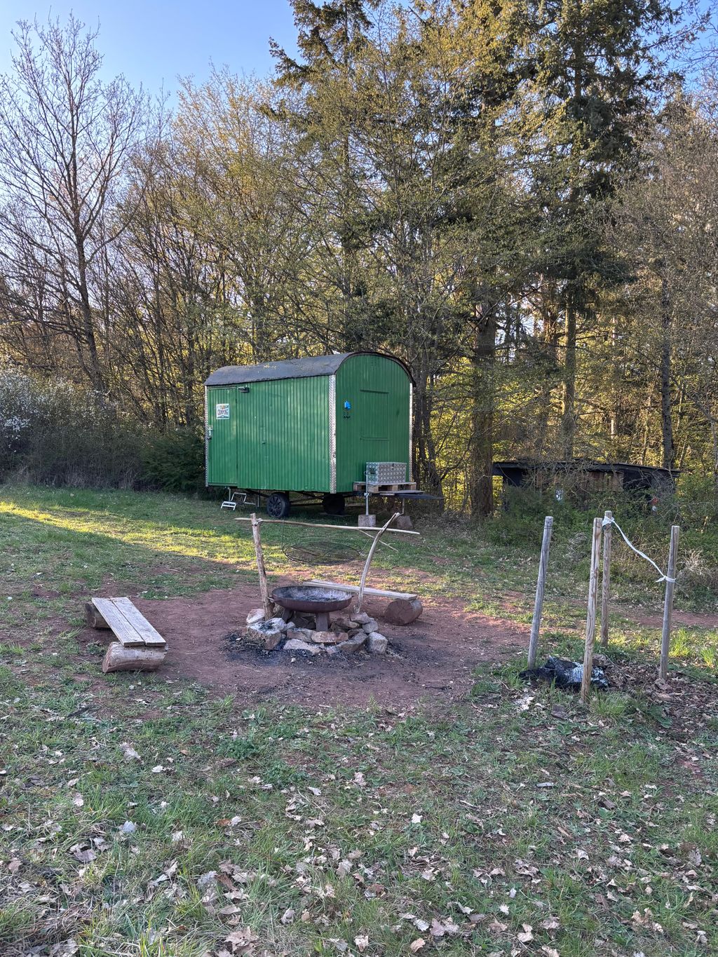 Gemütlicher Forstwagen auf der Wiese am Waldrand