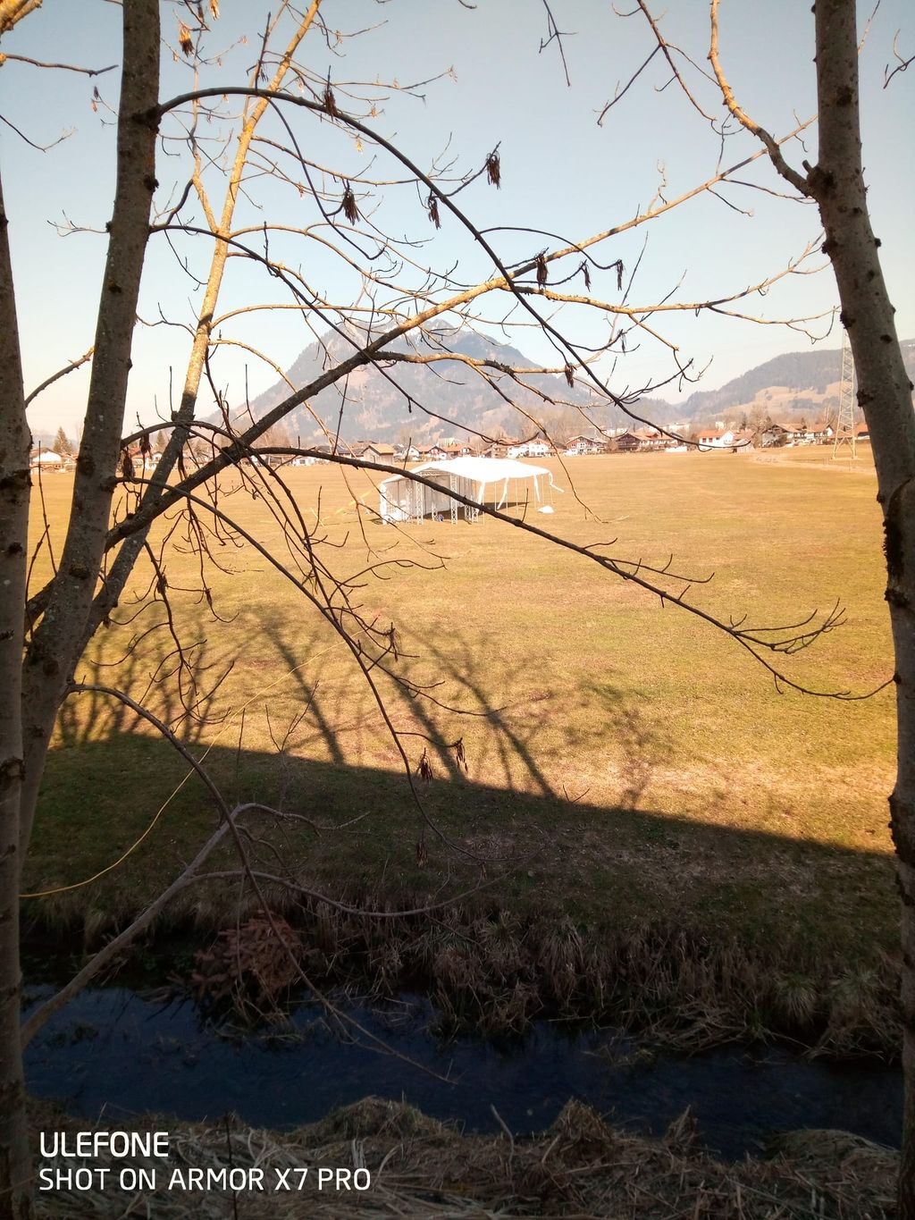 Panorama montano tra campi e sentiero di prati
