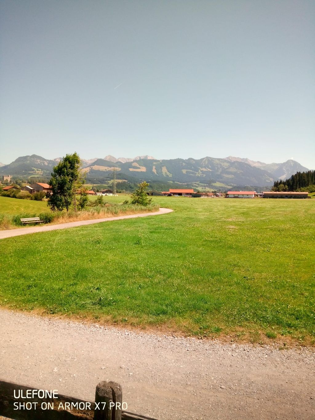 Panorama montano tra campi e sentiero di prati