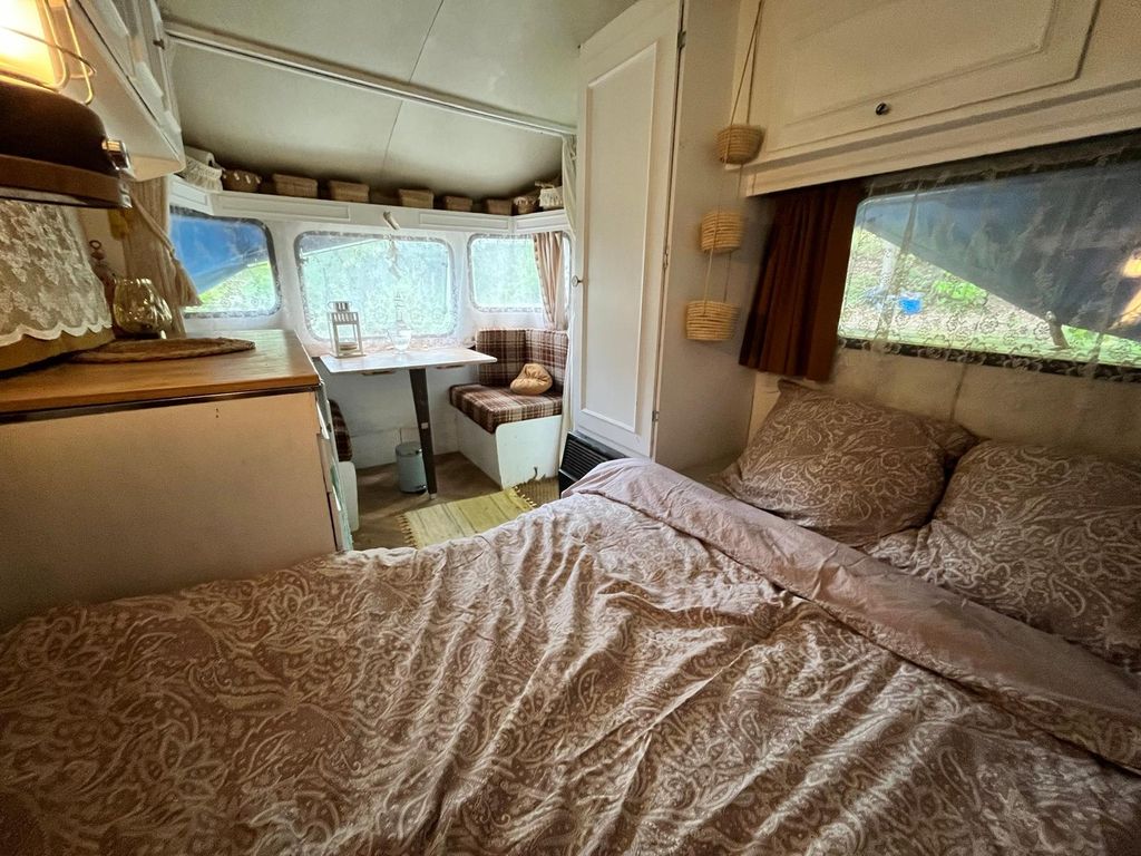 Autarker Retro-Wohnwagen in einem ruhigen Waldgarten