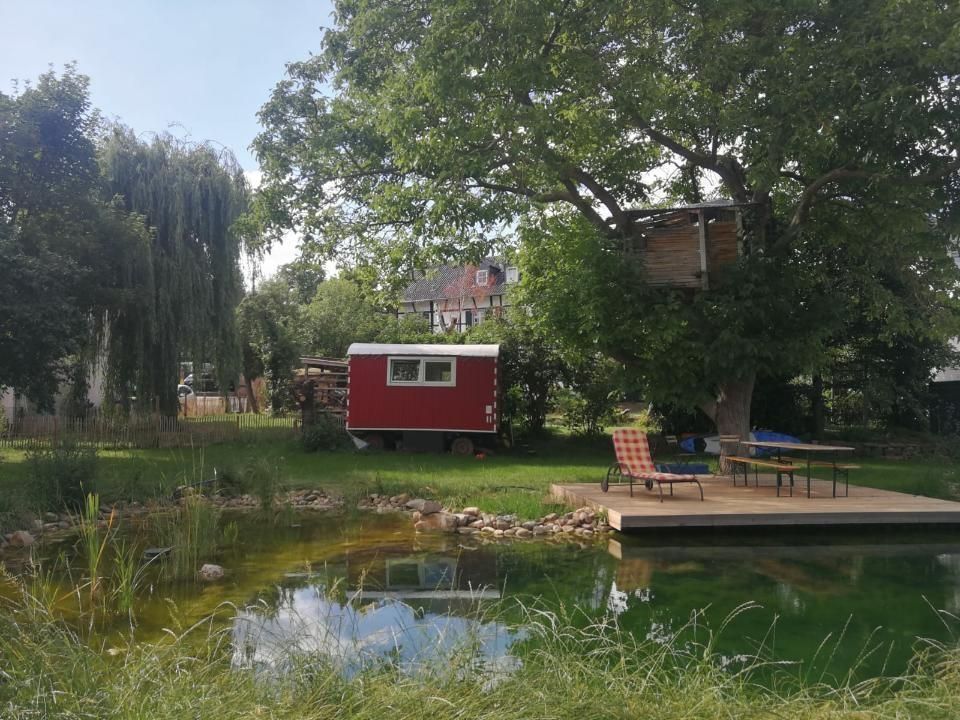 Construction trailer in a large garden with swimming pond
