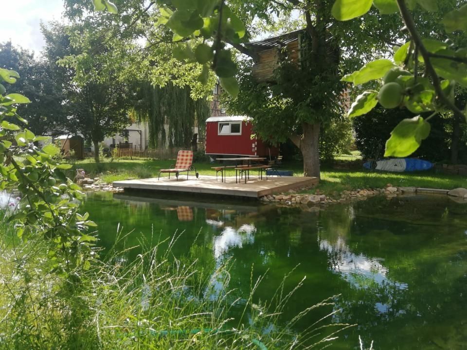 Construction trailer in a large garden with swimming pond