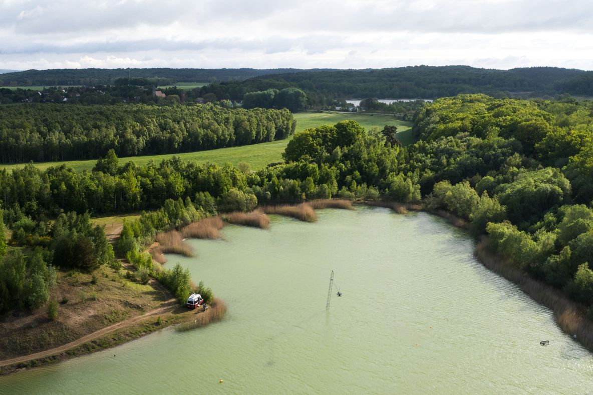 Camper steht direkt am Wasser eines Sees auf Rügen. Den Stellplatz kann man online über hinterland.camp buchen und er ist Teil des Ostsee-Roadtrips.