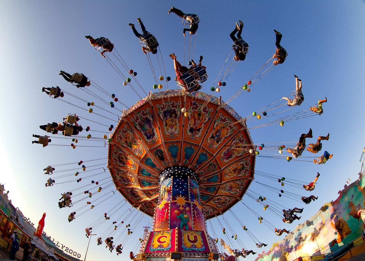 Man sieht ein sich bewegendes Riesenrad mit Menschen auf dem Oktoberfest