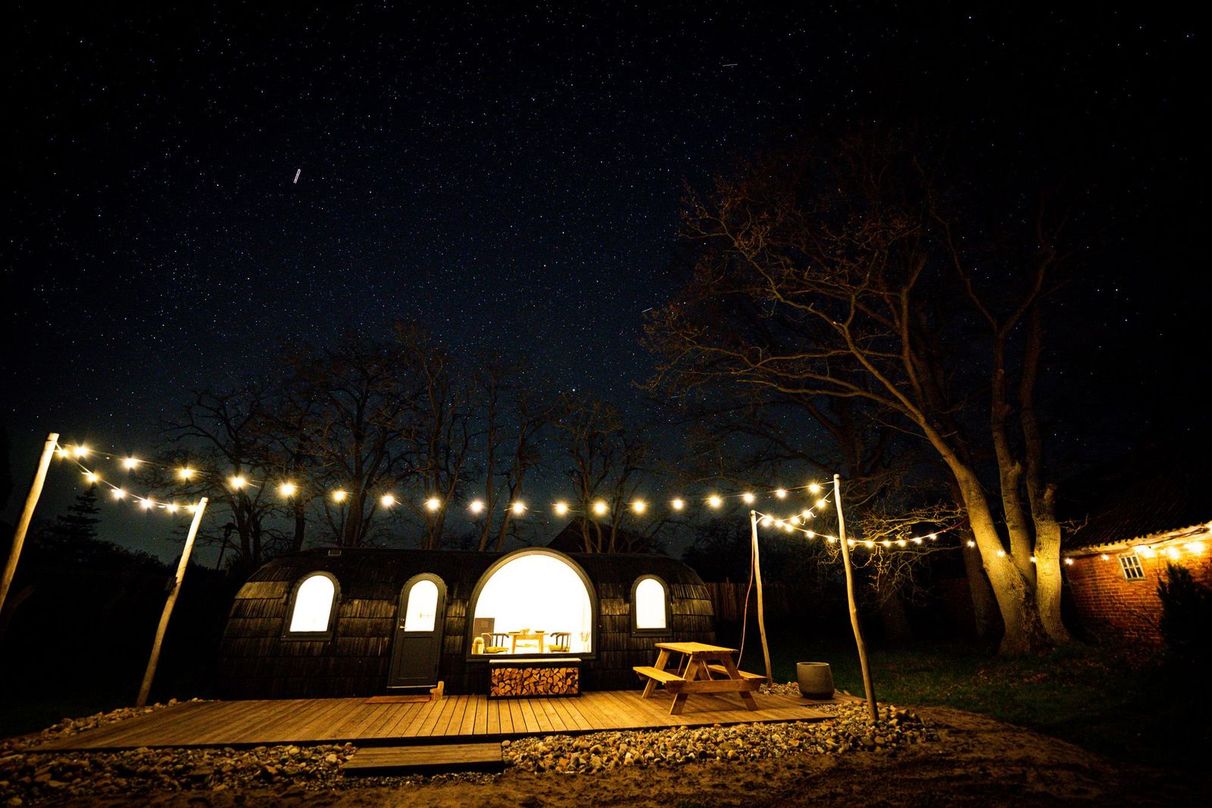 Tiny Haus / Cabin mit Lichterketten geschmückt bei Nacht von hinterland.camp