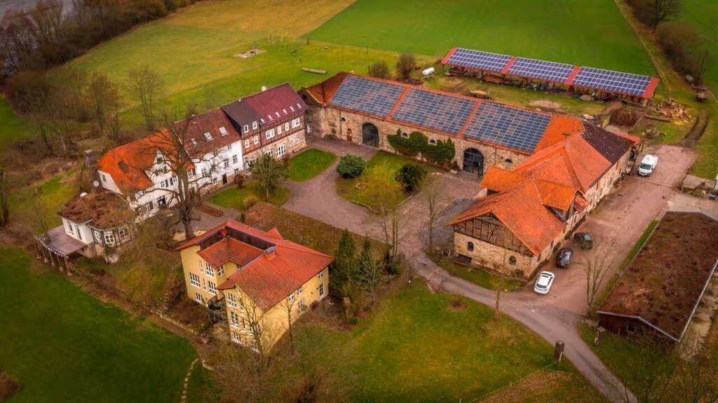 Aufnahme von dem Hof, bei dem man den Campingplatz besuchen kann, der auf einer Halbinsel an der Fulda umrahmt von Wasser liegt