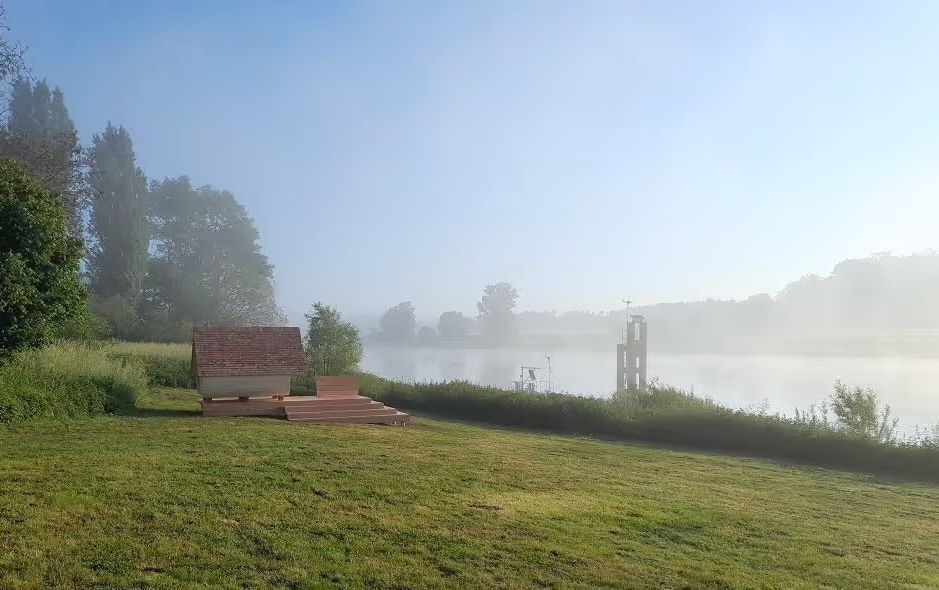 Weitwinklige Aufnahme eines Shelters, der direkt am Elbufer steht. Man kann eine Übernachtung bei hinterland.camp buchen.