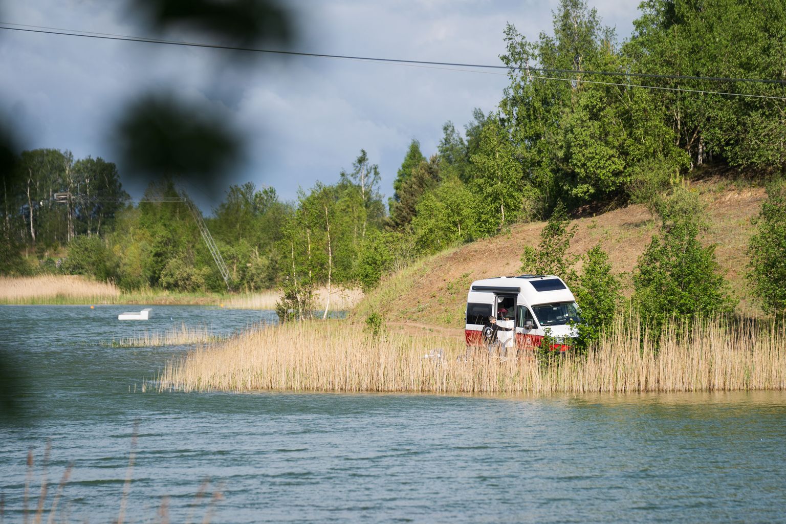 Camper steht direkt am Wasser an einem Camping-Stellplatz auf Rügen, den man über hinterland.camp buchen kann. Er ist Teil des Roadtrips entlang der Ostsee.