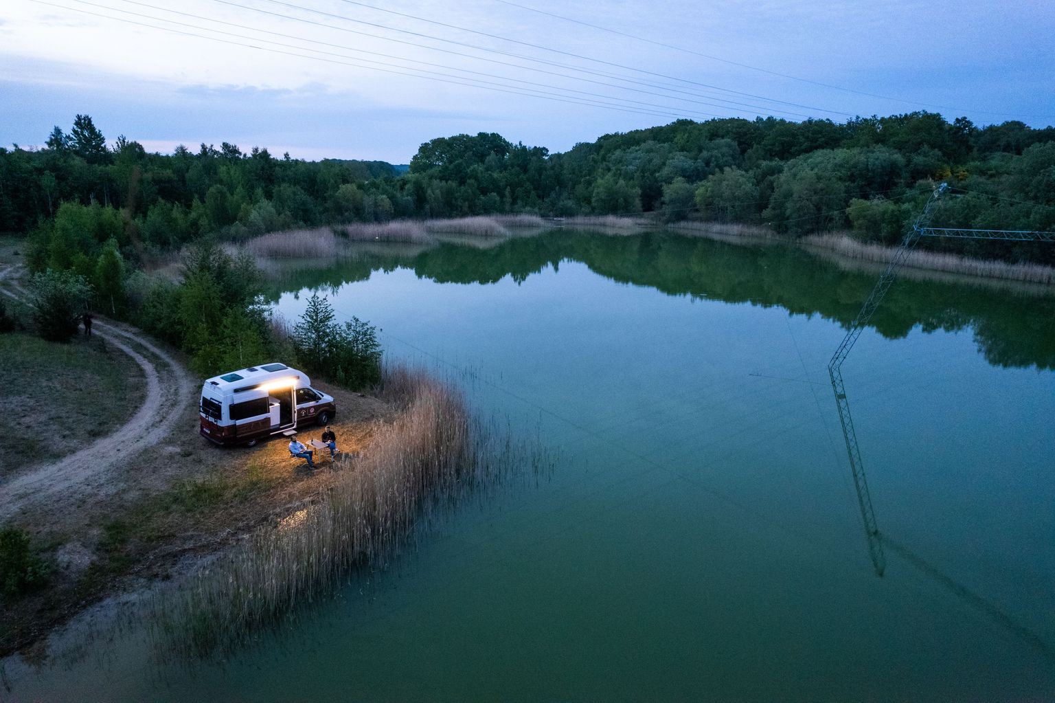 Camper steht an einem Stellplatz mit direkter Lage zum See auf Rügen in Alleinlage
