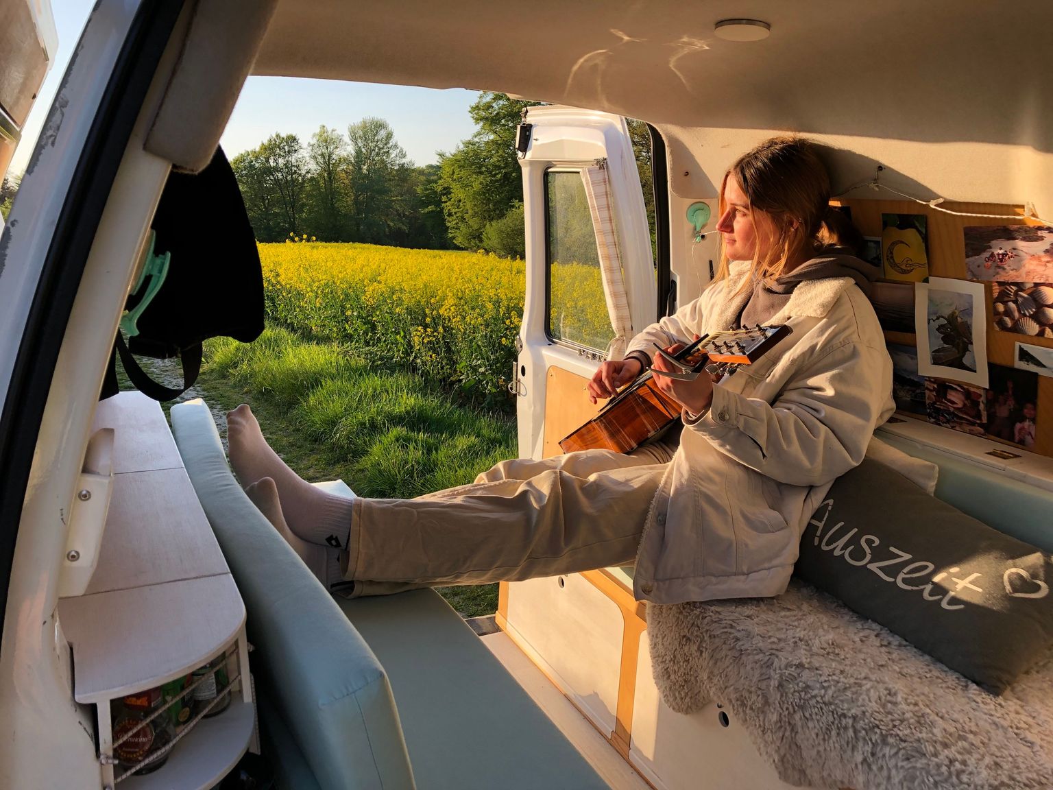 Hinterland-Mitarbeiterin beim Gitarrenspielen im Van