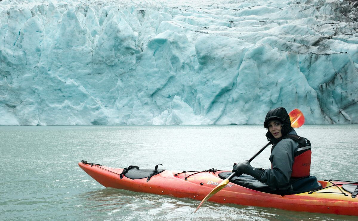 Imke fährt Kayak vor einem Berg aus Eis