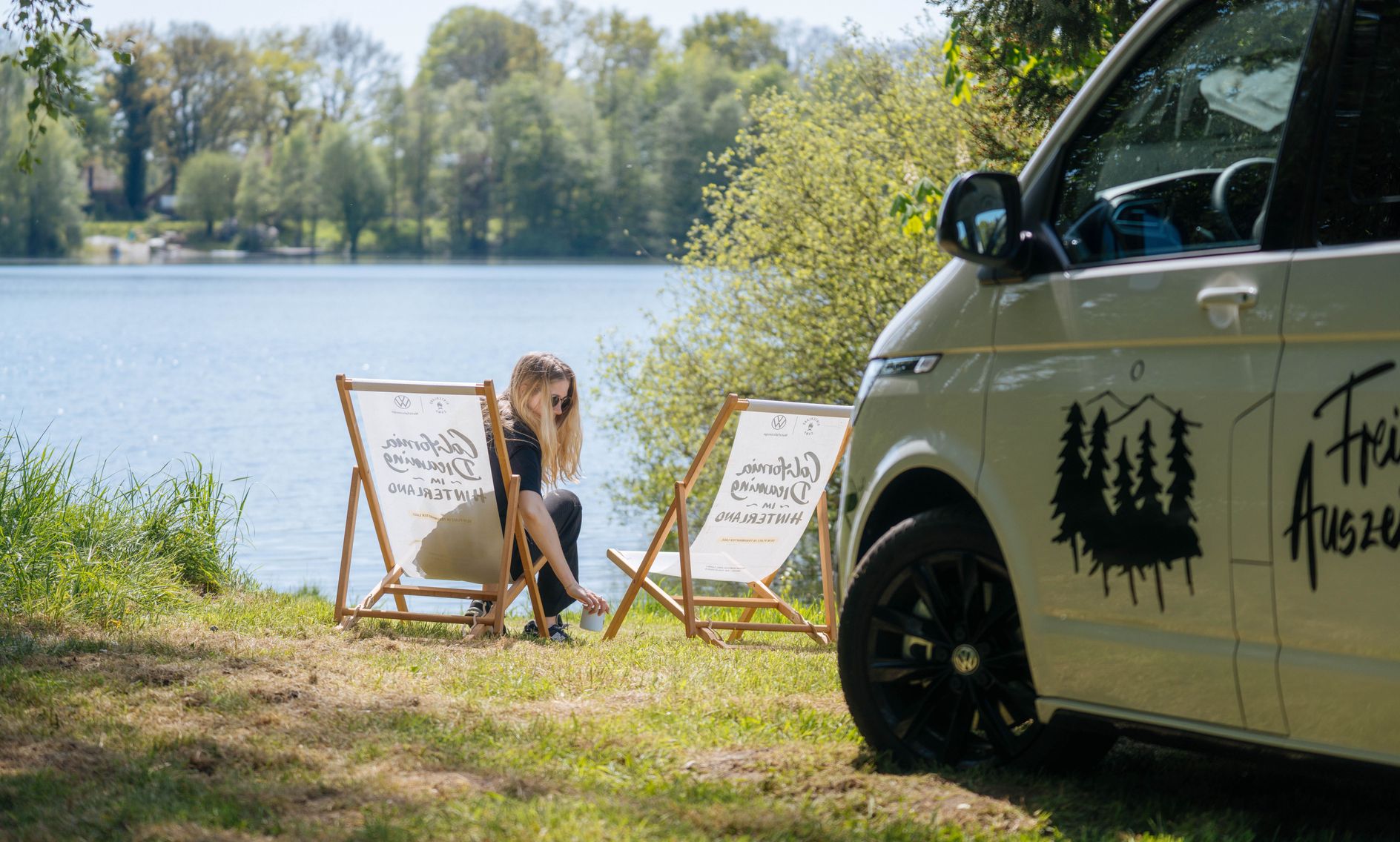 Camper steht auf einem Wohnmobil Stellplatz direkt am Wasser, buchbar bei hinterland.camp