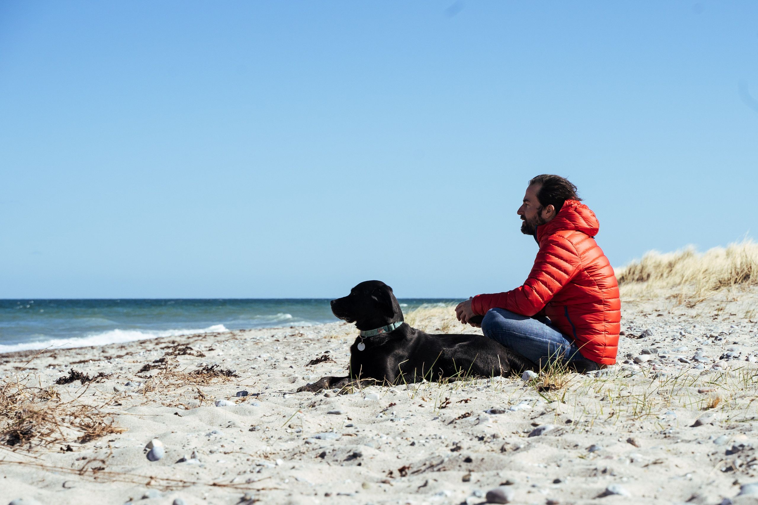Hinterland-Mitarbeiter Oli mit Hund am Strand
