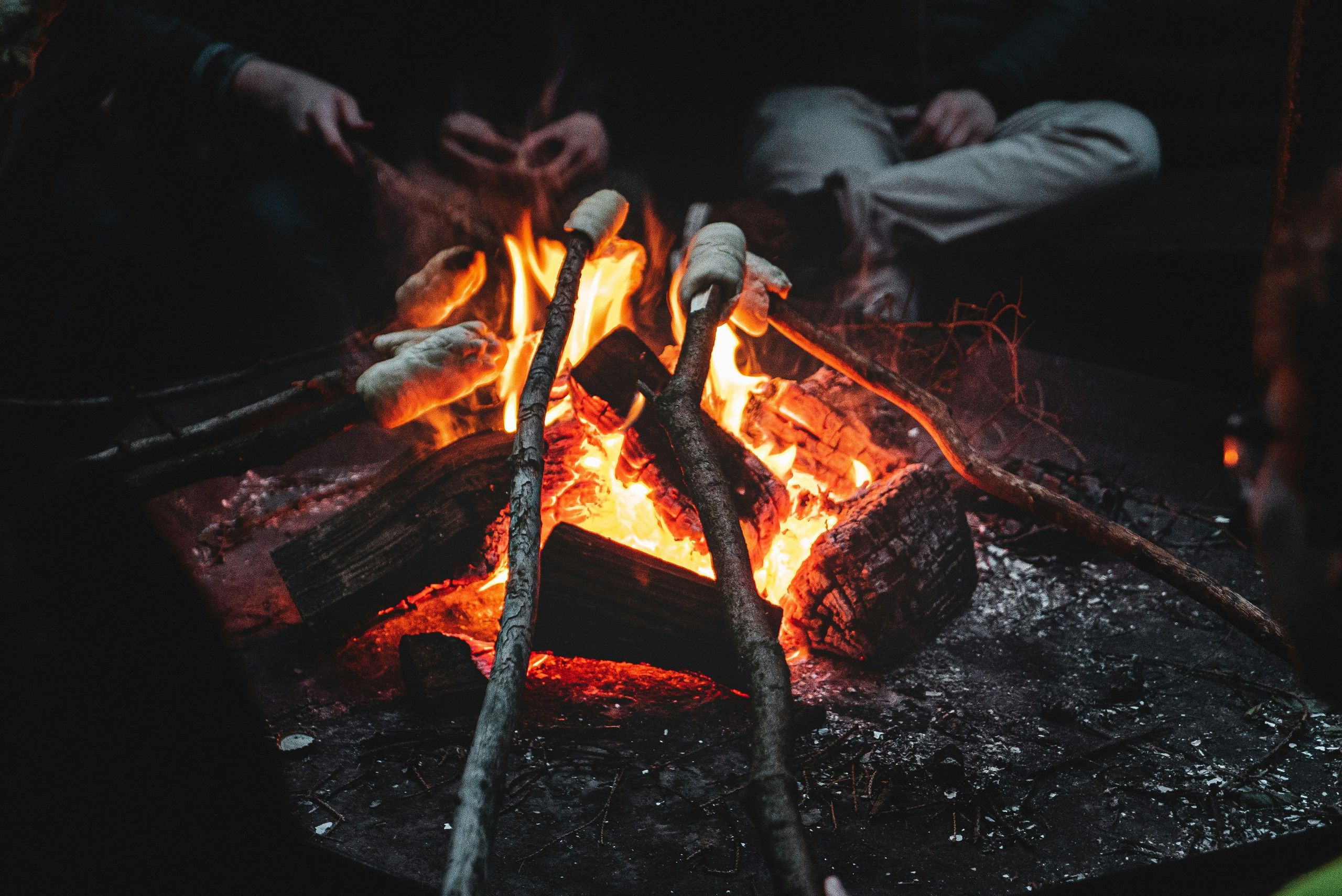 Nahaufnahme eines Lagerfeuers mit Stockbrot