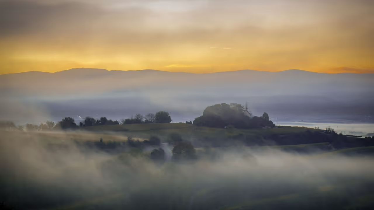 Wunderschöner Sonnenuntergang, der eine Portrait des Bergpanoramas zeichnet. Diesen Blick kann man beim Camping Münstertal von einem der Stellplätze aus betrachten. Buchbar sind die Stellplätze auf hinterland.camp.