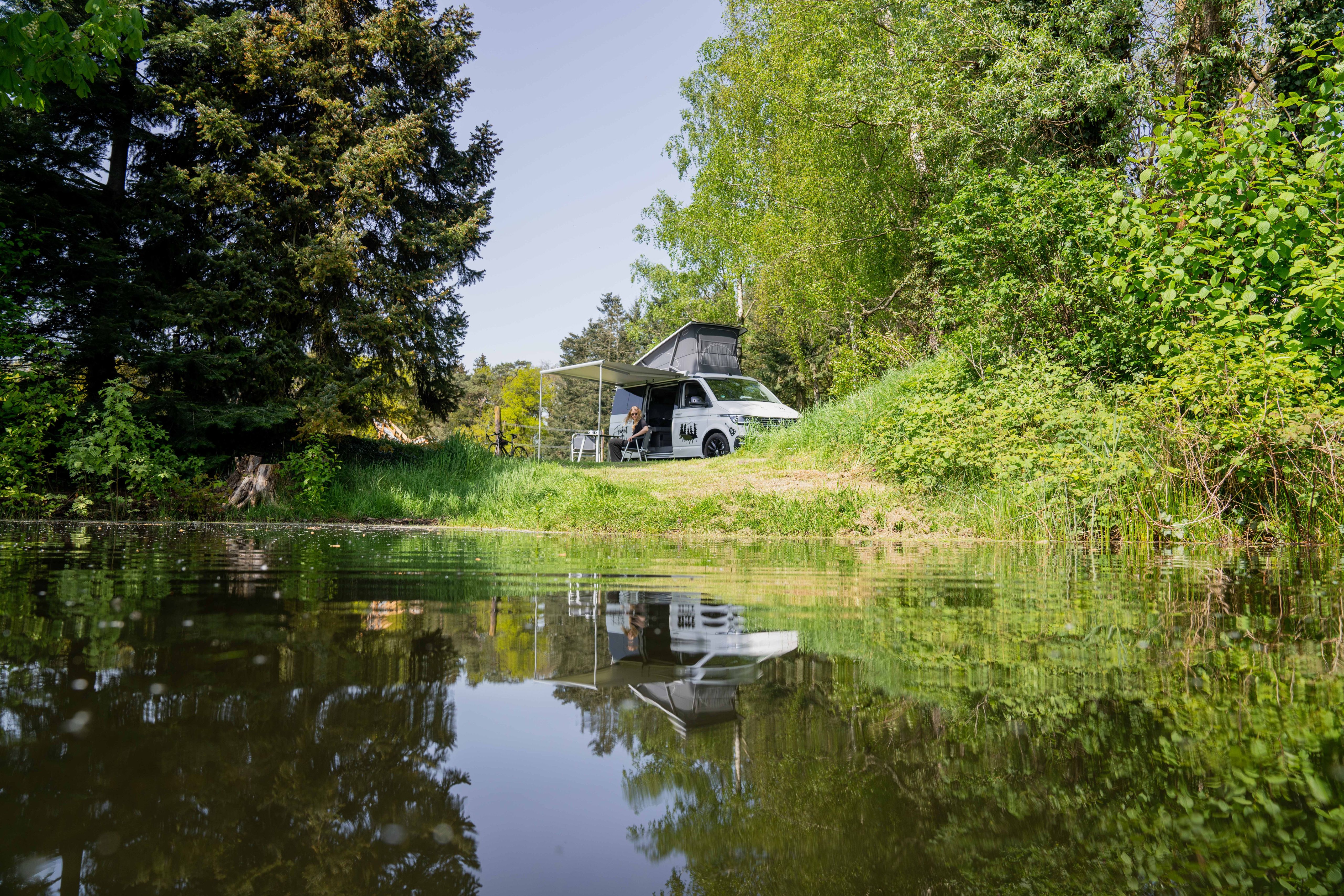 Camper steht auf einem Wohnmobil Stellplatz direkt am Wasser in Niedersachsen, buchbar bei hinterland.camp