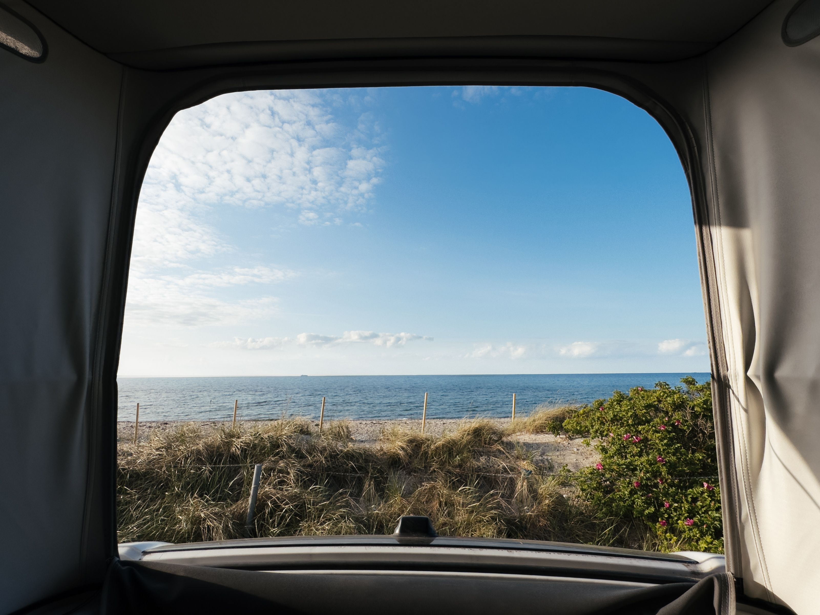 Camper steht auf einem Wohnmobil Stellplatz direkt am Wasser, buchbar bei hinterland.camp