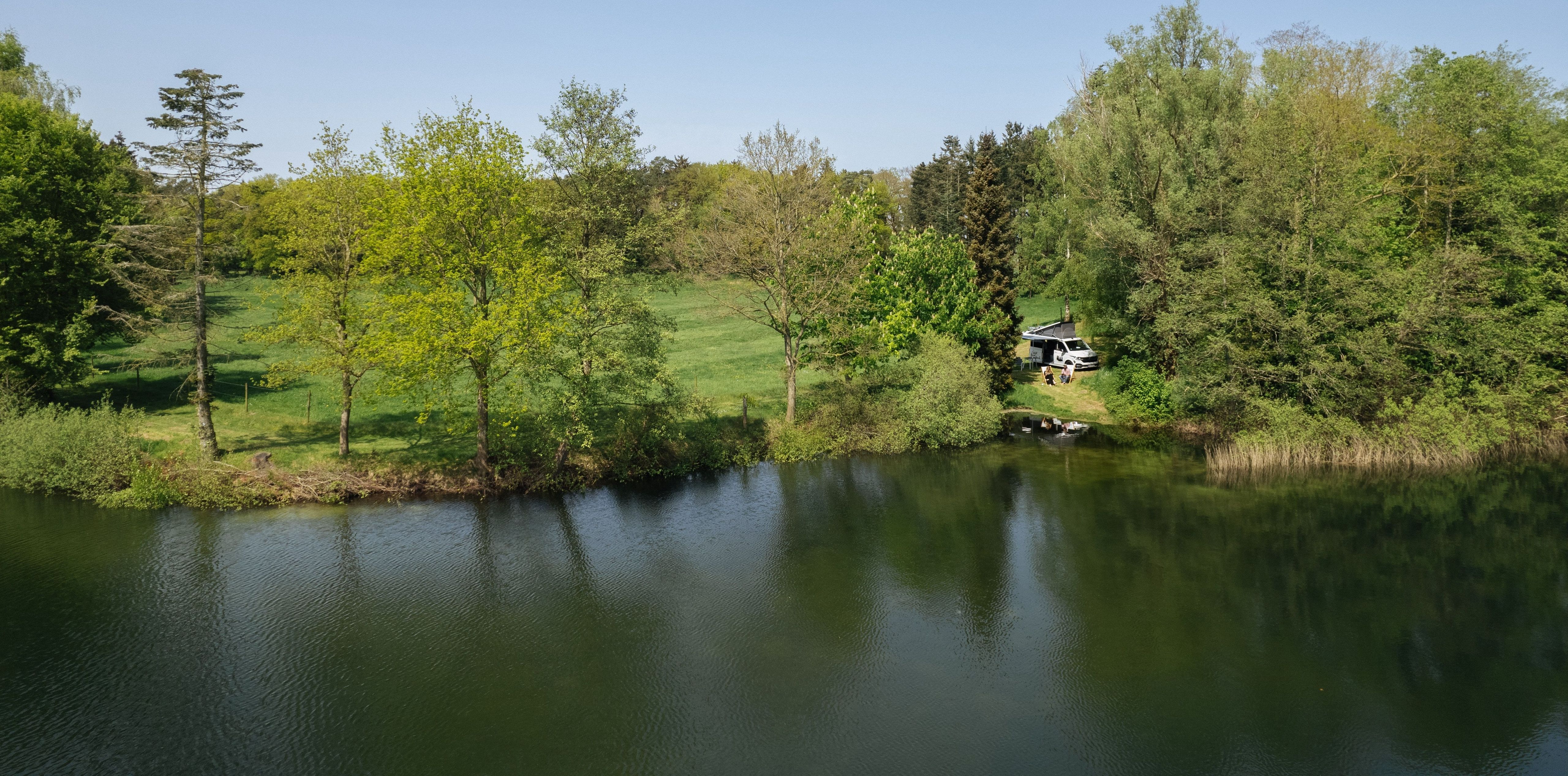 Camper steht direkt am See in Alleinlage auf einem Stellplatz von hinterland.camp