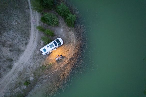 Camper steht an einem Stellplatz mit direkter Lage zum See auf Rügen in Alleinlage