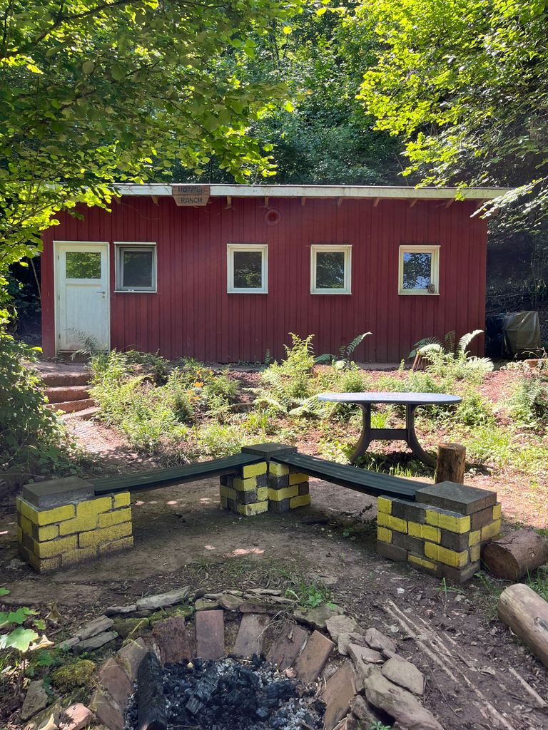 Hütte mit Sitzbank an Feuerstelle