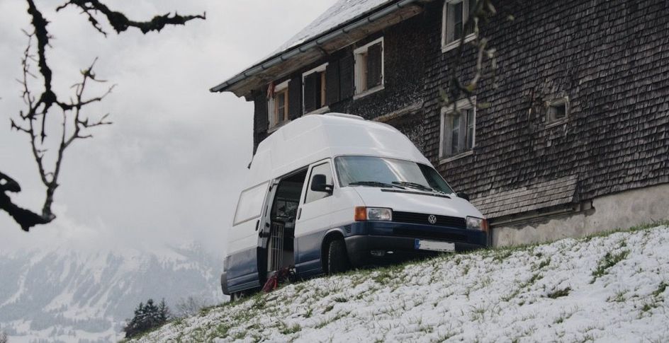 eingeschneiter Camper steht auf einem Stellplatz von hinterland.camp