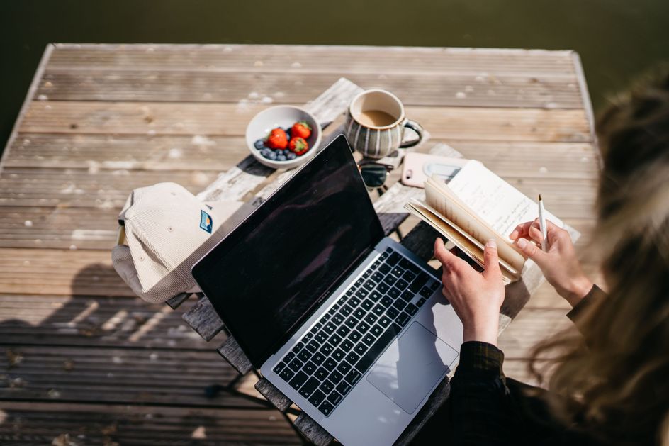 Frau macht workation am Laptop auf einem Stellplatz von hinterland.camp