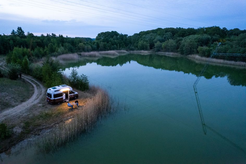Camper steht an einem Stellplatz mit direkter Lage zum See auf Rügen in Alleinlage